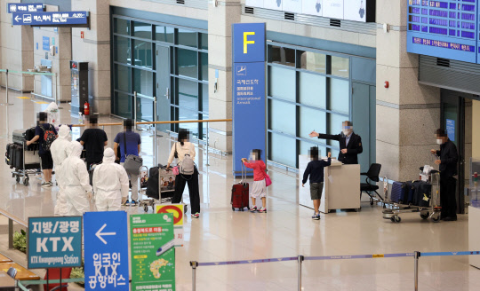 코로나19가 대확산 중인 인도에서 특별기를 통해 귀국한 교민들이 12일 오전 인천국제공항 1터미널에 도착해 입국장을 나서고 있다. 인도발 한국행 특별기는 이달 들어 네 번째로 마련됐다.  연합뉴스